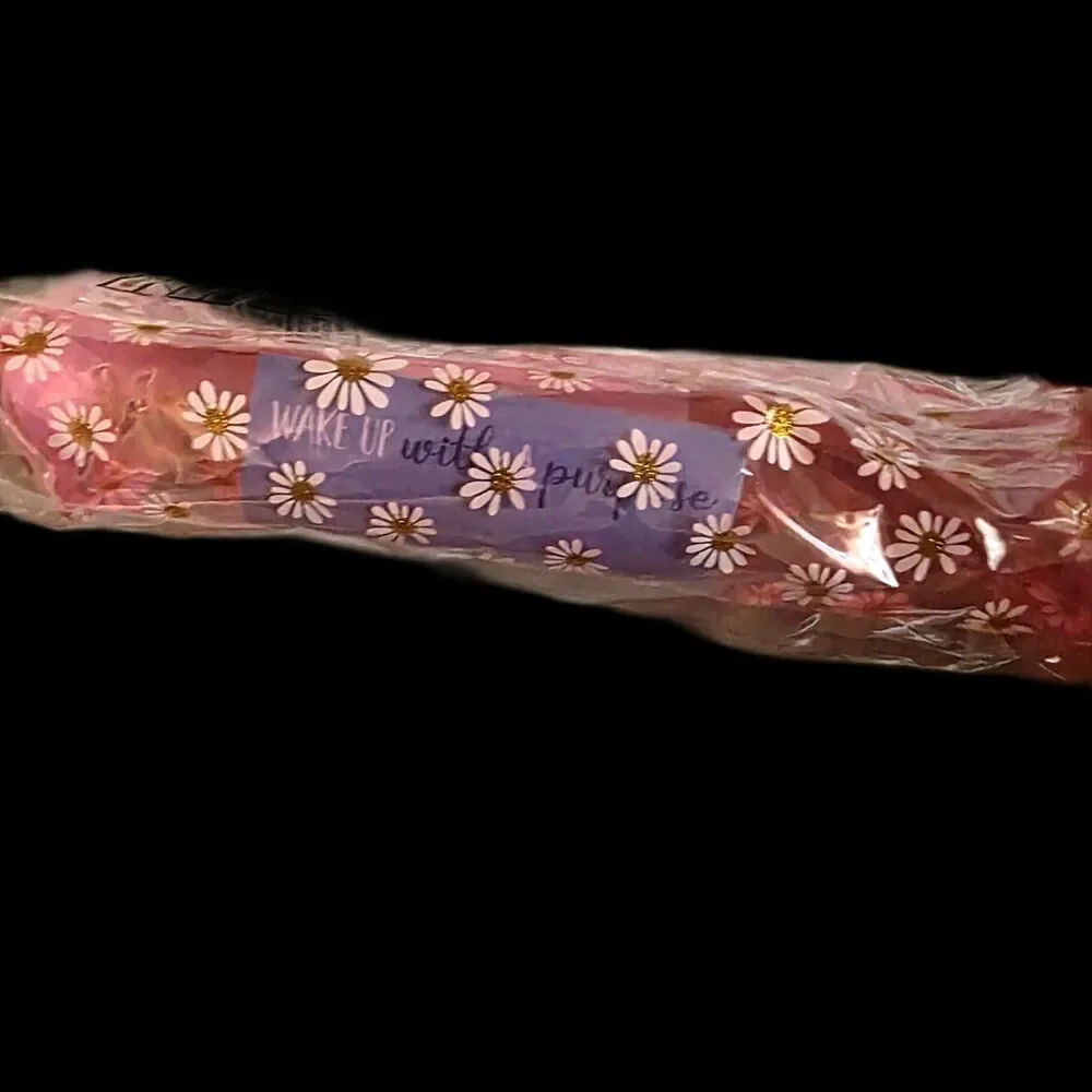 Transparent pink daisy-patterned zippered pencil case or makeup pouch.